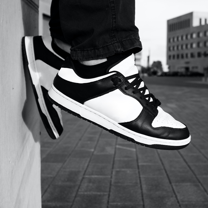 Custom Low Top Sneakers Black and white photo of a person wearing low-top sneakers