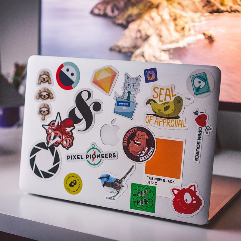 How custom stickers can transform your brand There are many stickers on the back of a macbook