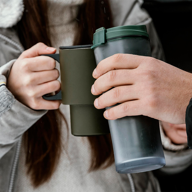 Why sell Custom tumbler cups online Two people are holding a thermos cup and doing a toast gesture